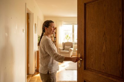 Femme choisissant une porte battante en bois chêne dans un couloir intérieur chaleureux